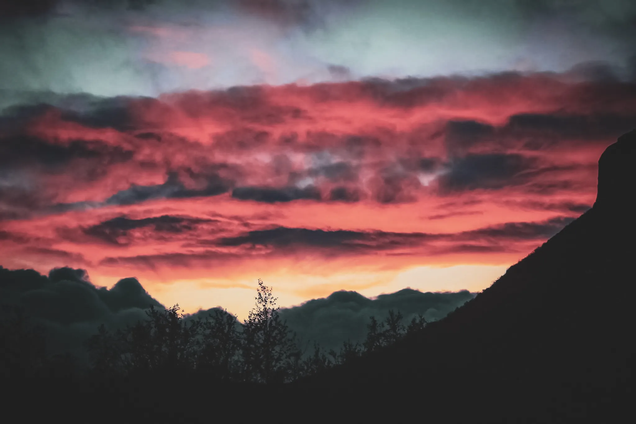 A blazing sunset over the mountains and clouds of Lapland, an invitation to adventure.