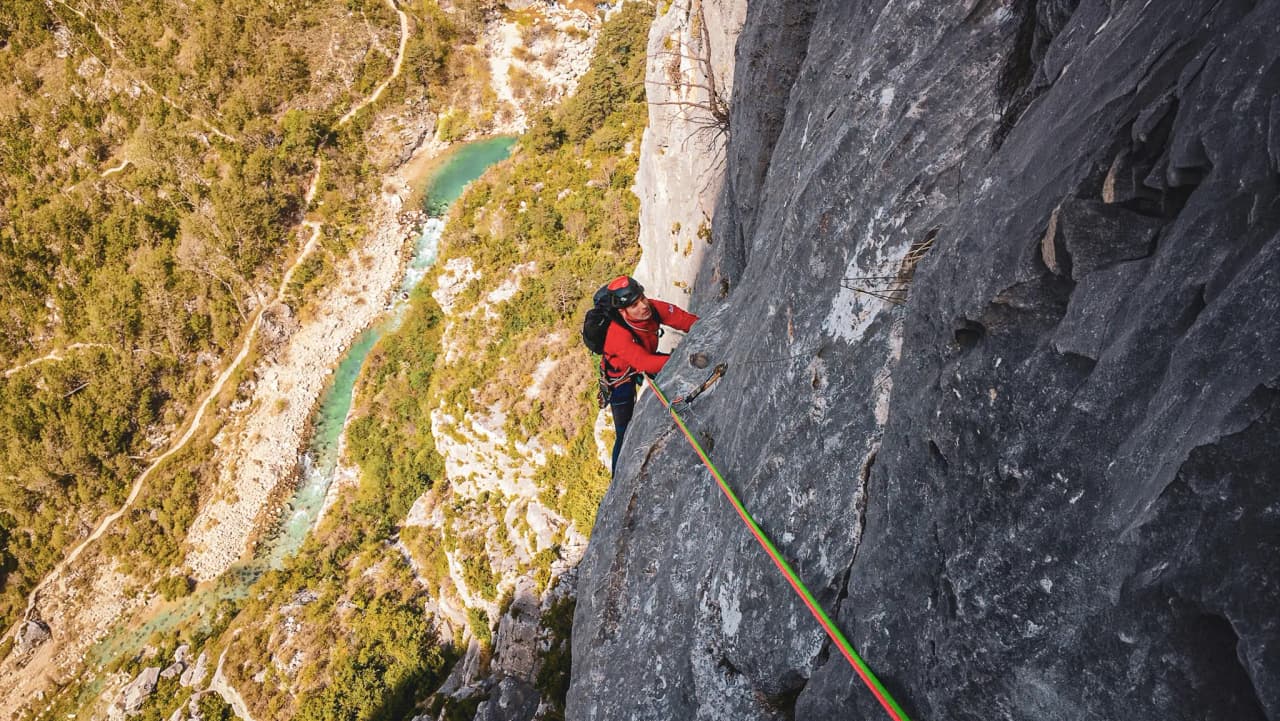 Climbing in the Gorges du Verdon, overlooking a turquoise river, a breathtaking natural setting.