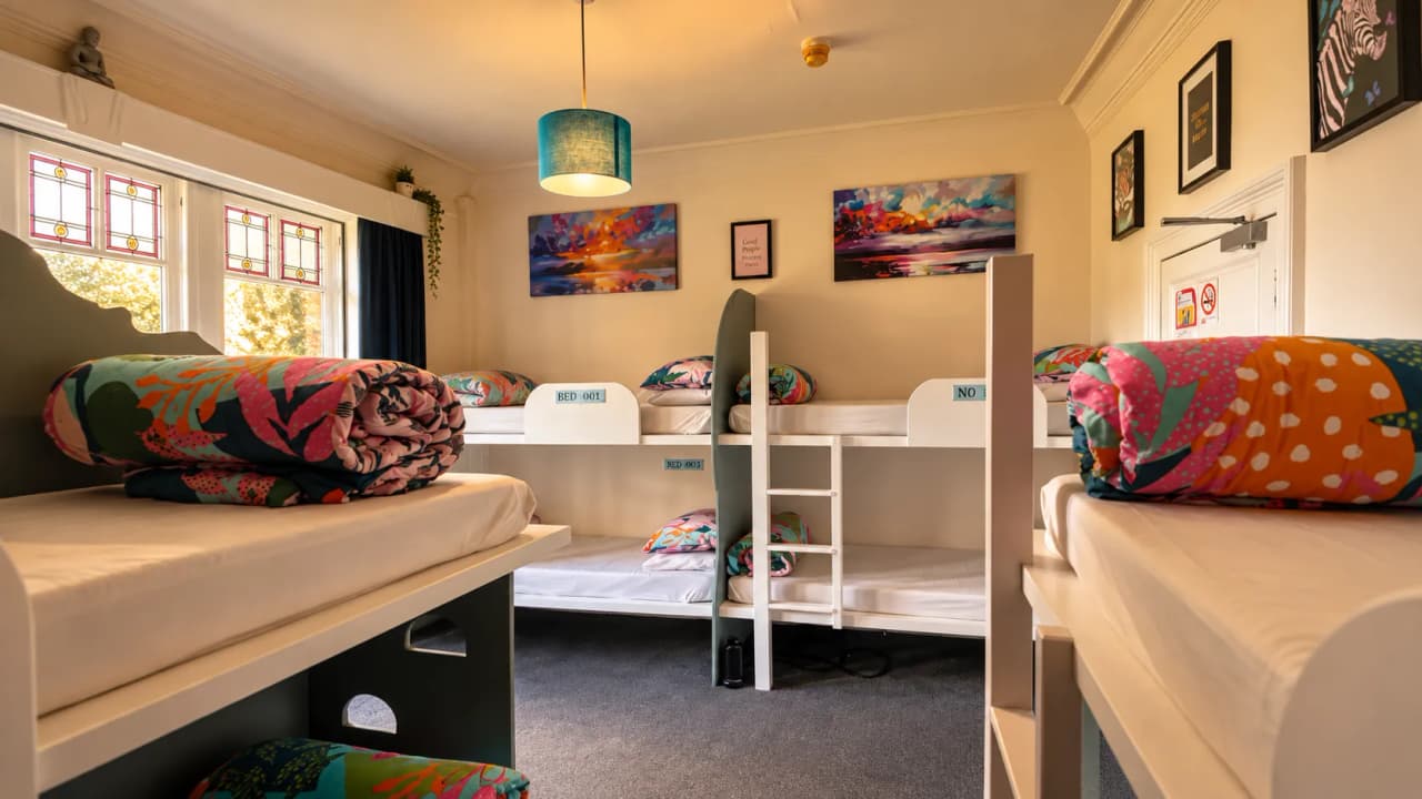 A dorm room with bunk beds and colourful blankets in one of our hostels