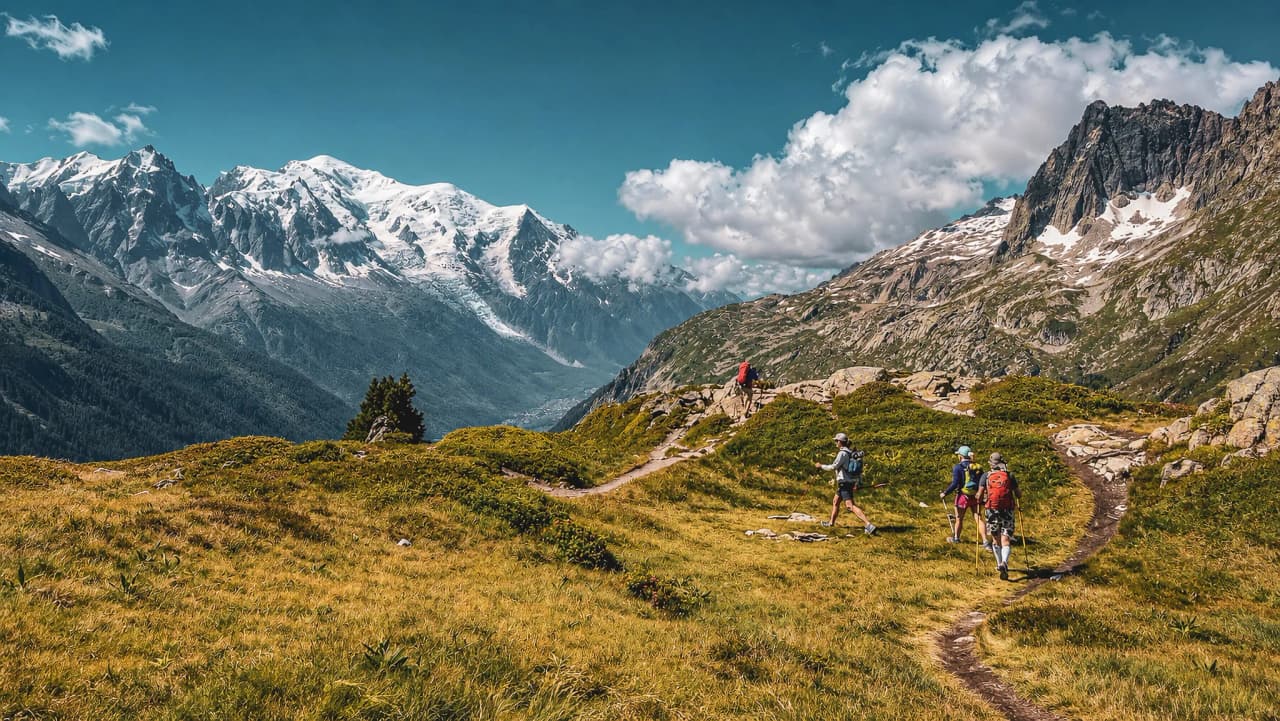 Alpine wandelen in de Dévoluy, met een spectaculair landschap en besneeuwde toppen aan de horizon.