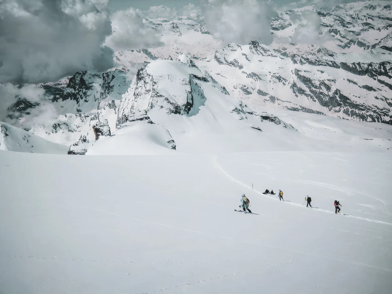 Groupe de skieurs en ascension sur un paysage alpin enneigé au Grand Paradis. Spectacle majestueux !