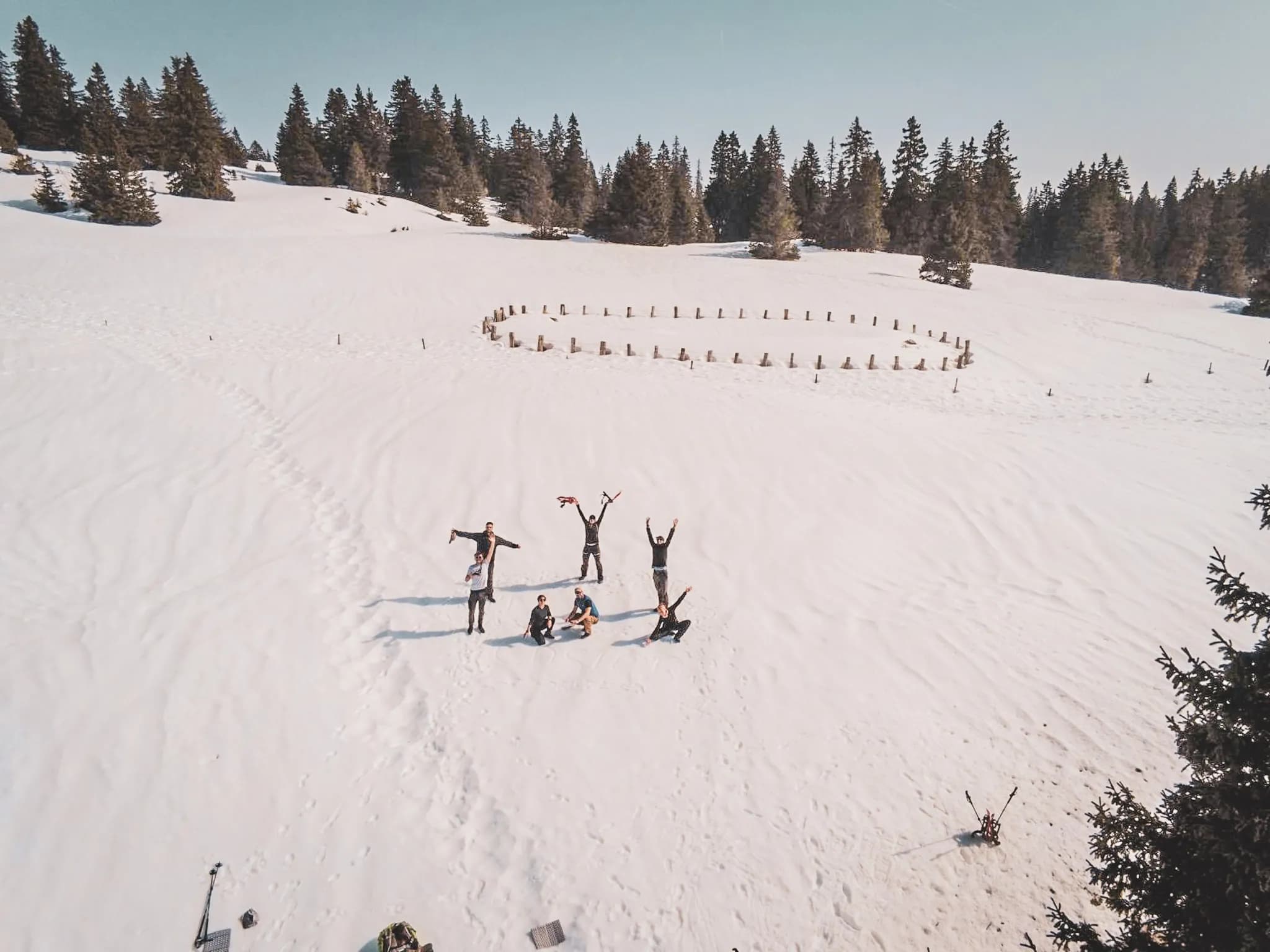 A group of adventurers on snowshoes in a snowy landscape surrounded by majestic fir trees.