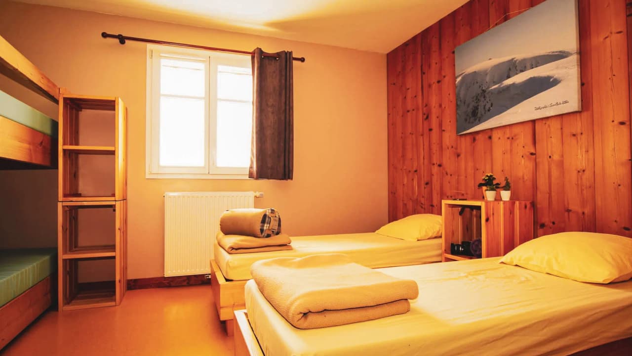 Chambre conviviale au refuge, confort simple, ambiance chaleureuse, idéale après une journée de trail.