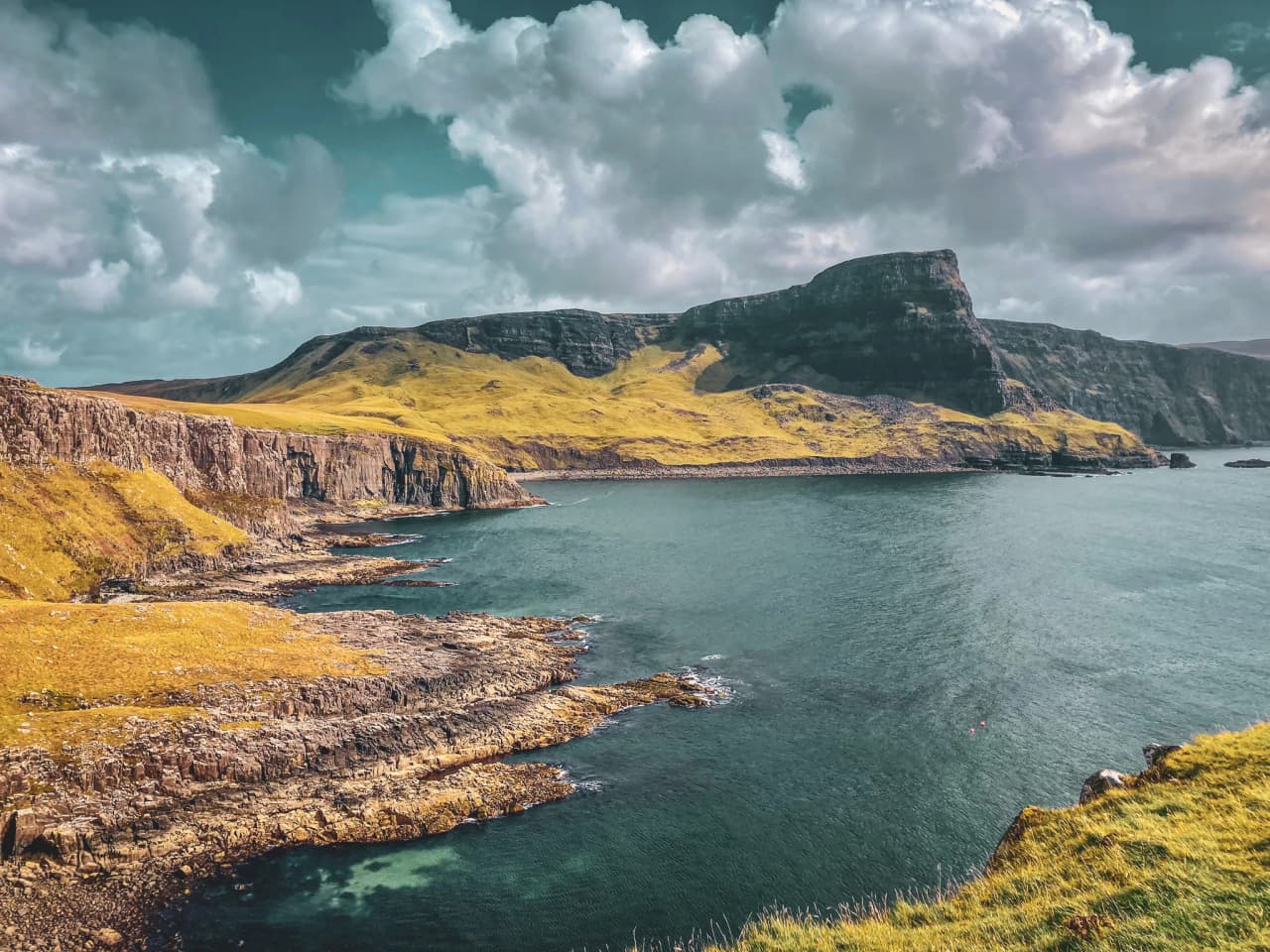 Paysages époustouflants de l'île de Skye, falaises dorées surplombant des eaux scintillantes.