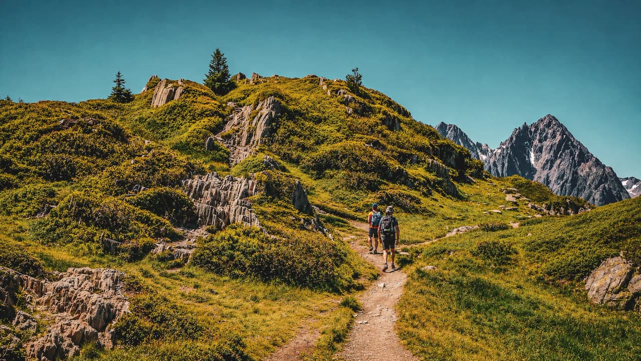 Wandelen in de Dévoluy: weelderig groene paden en majestueuze bergtoppen op de achtergrond.