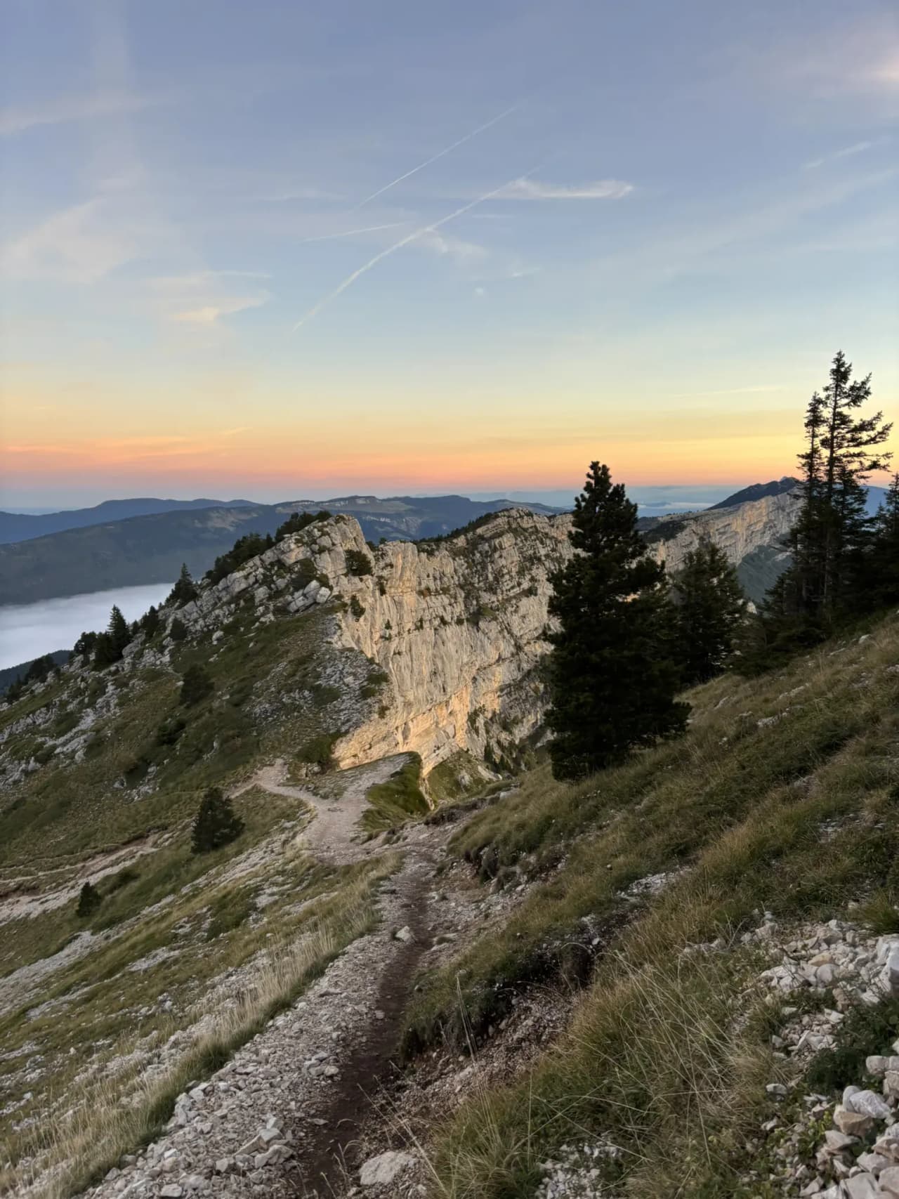 A wild panorama of the Atlantic Vercors, winding paths beneath a colourful sky at dusk.