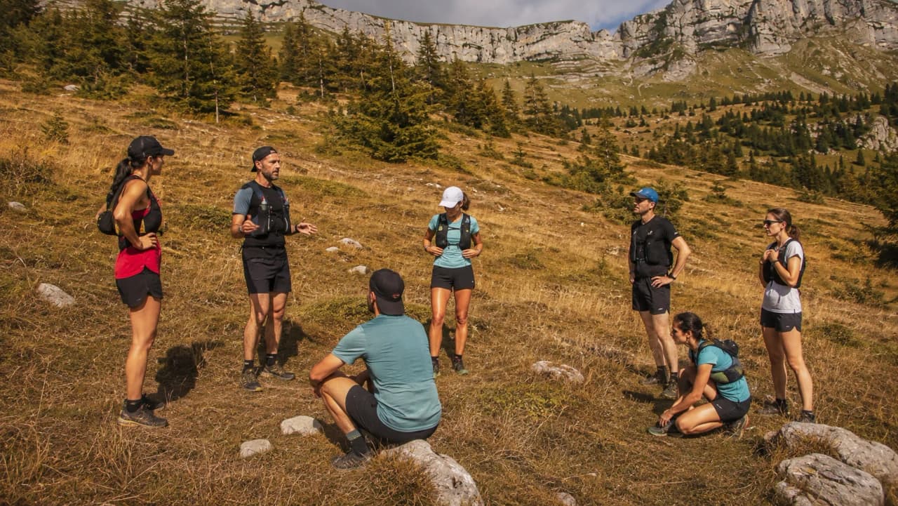 Un groupe de coureurs en pleine discussion dans les montagnes ensoleillées de Chartreuse.