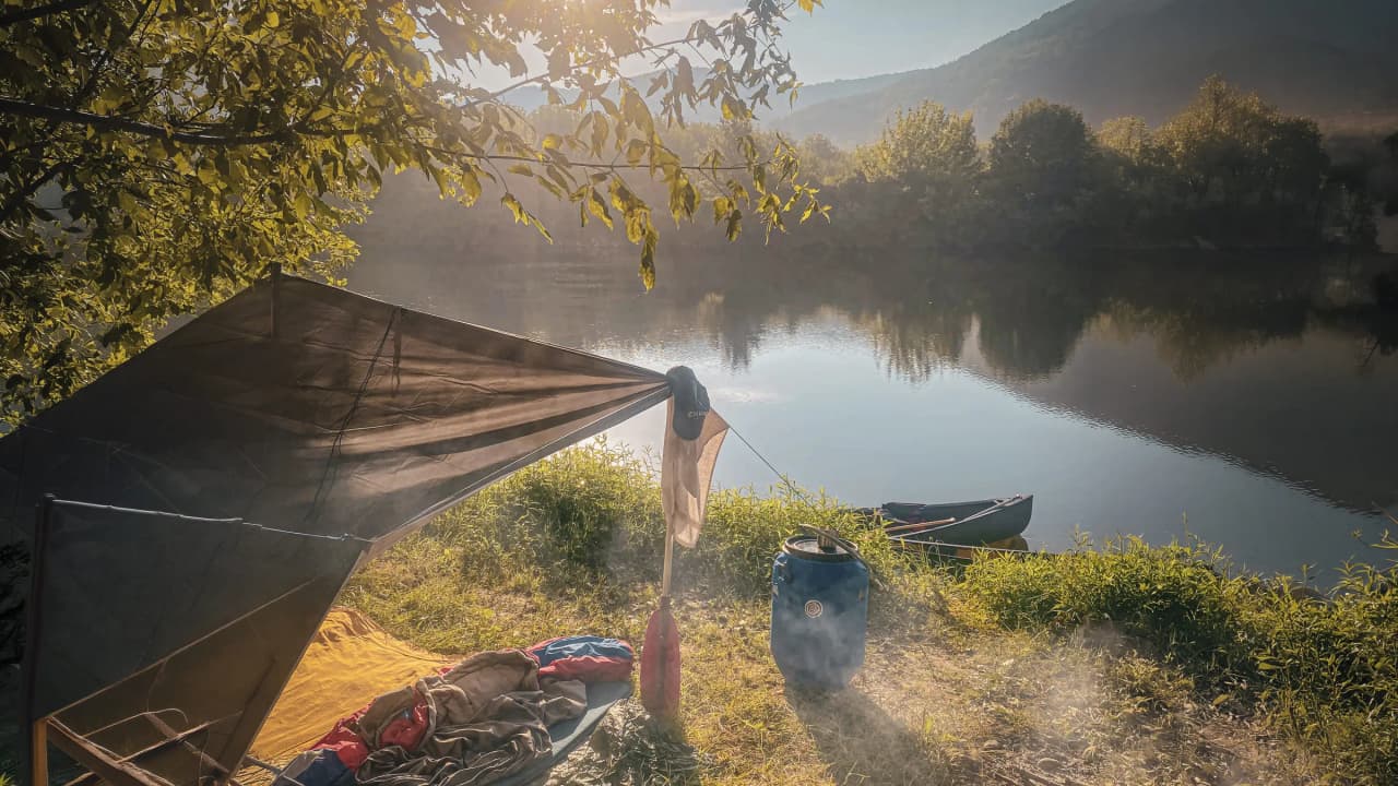 Bivouac paisible au bord de la Dordogne, canoë et nature au lever du soleil.