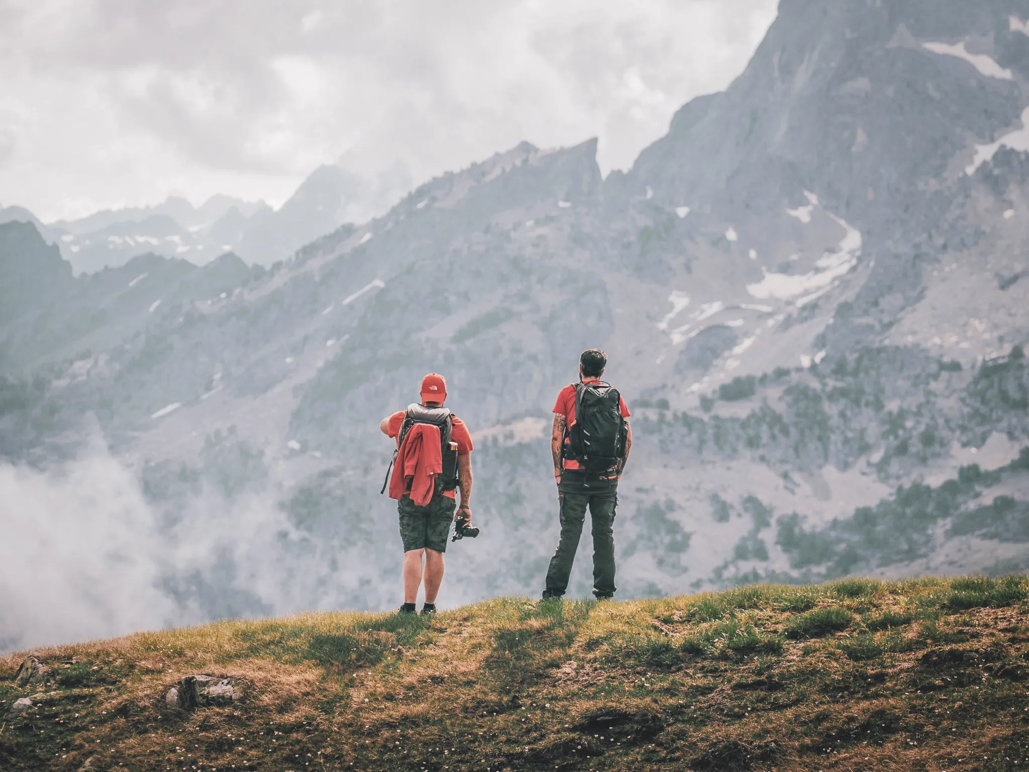 Twee wandelaars bewonderen de majestueuze bergen van de Pyreneeën, klaar voor avontuur.