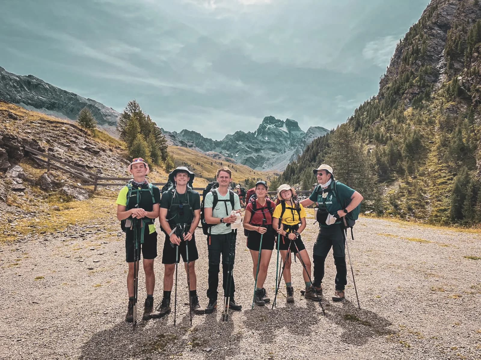 Groupe de randonneurs souriants devant des montagnes majestueuses, prêt à explorer le Mont Viso.