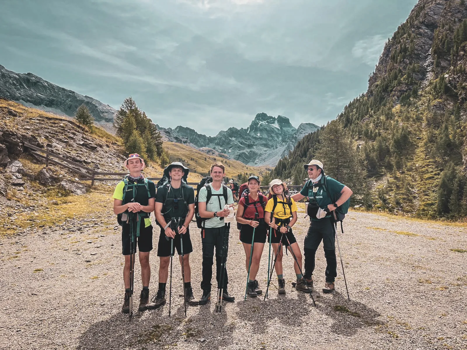Groupe de randonneurs souriants devant des montagnes majestueuses, prêt à explorer le Mont Viso.