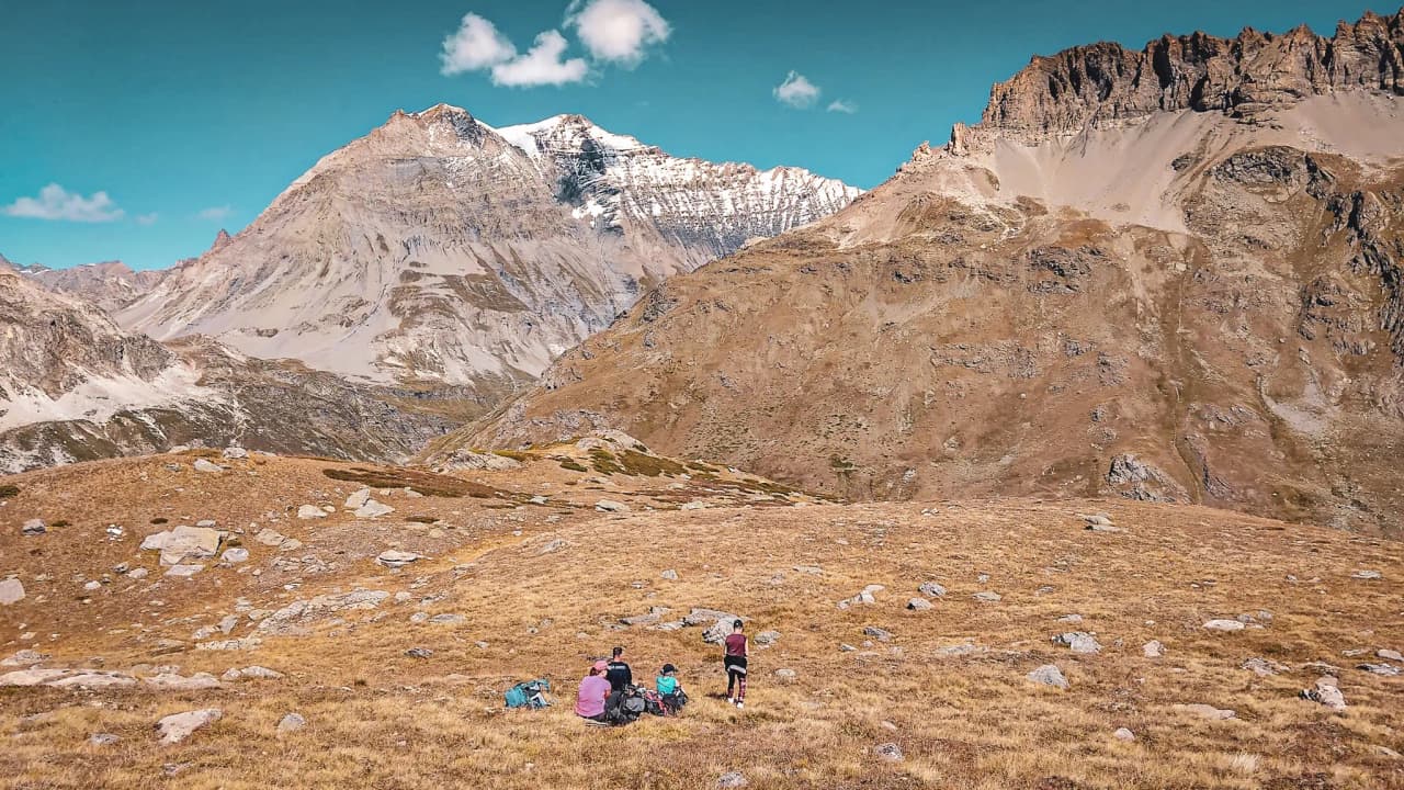 Wandelaars bewonderen de majestueuze toppen van het Vanoise National Park onder een blauwe hemel.