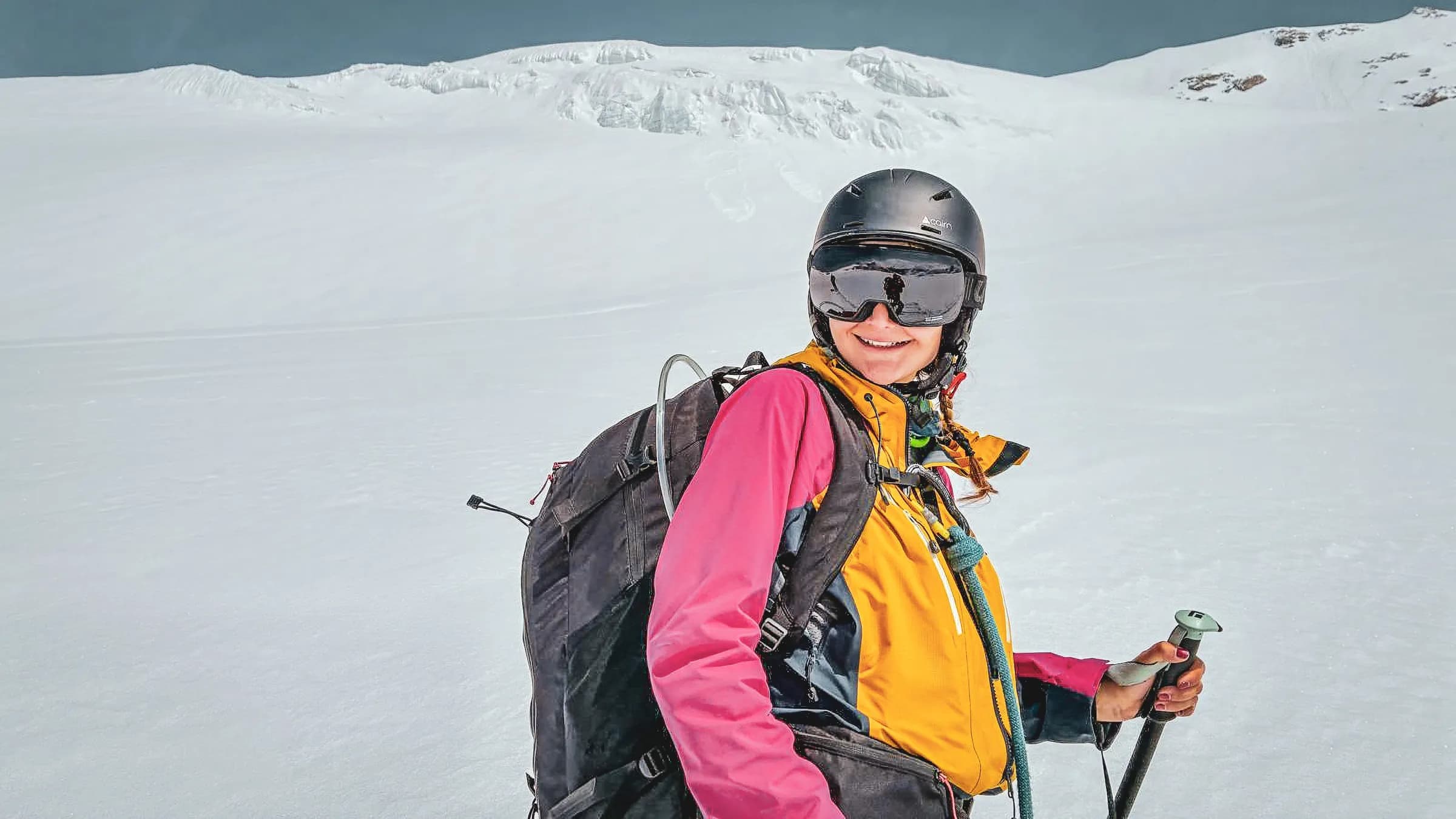 Skieuse souriante sur un glacier, prête pour l'aventure dans les Alpes.