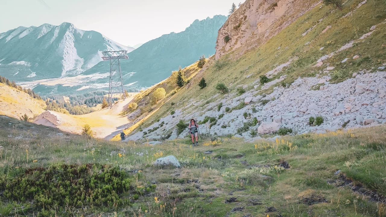 Hikers on a green trail, surrounded by majestic mountains in Dévoluy.