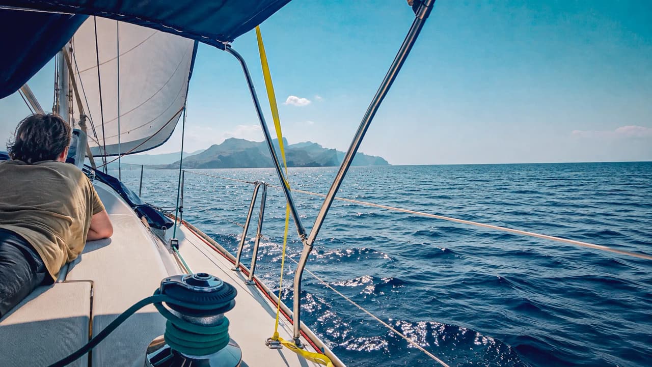 Cruise peacefully across the turquoise waters of the Balearic Islands, with mountainous landscapes in the background.