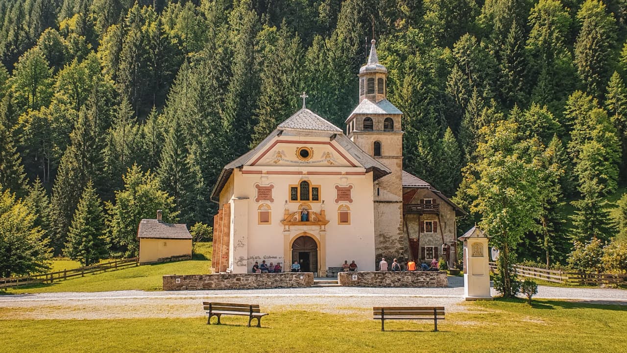 A picturesque church surrounded by greenery, an invitation to discover the Alps.
