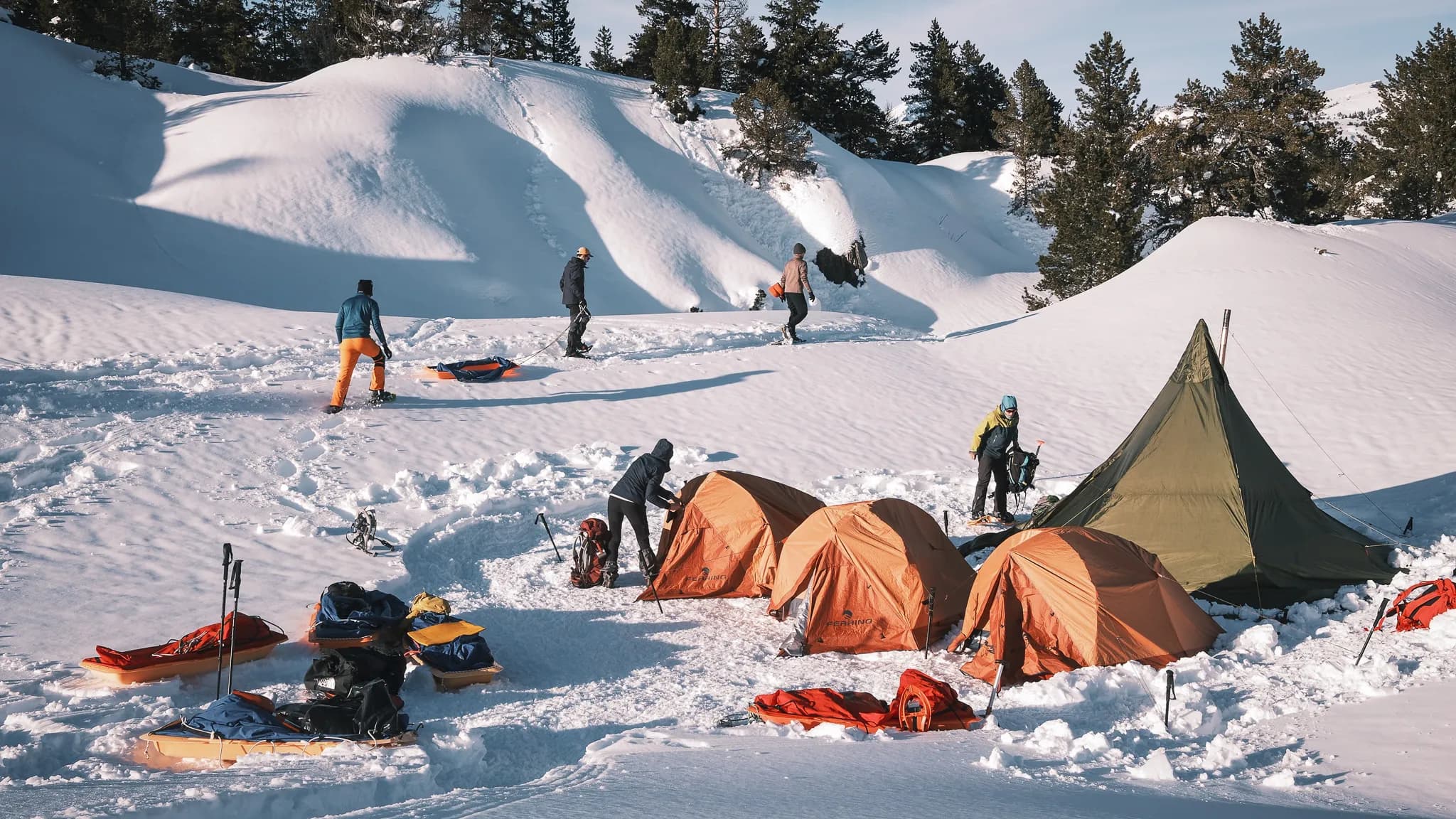 Groupe en pleine nature, bivouac sous tipi, neige éclatante et paysages montagneux à couper le souffle.