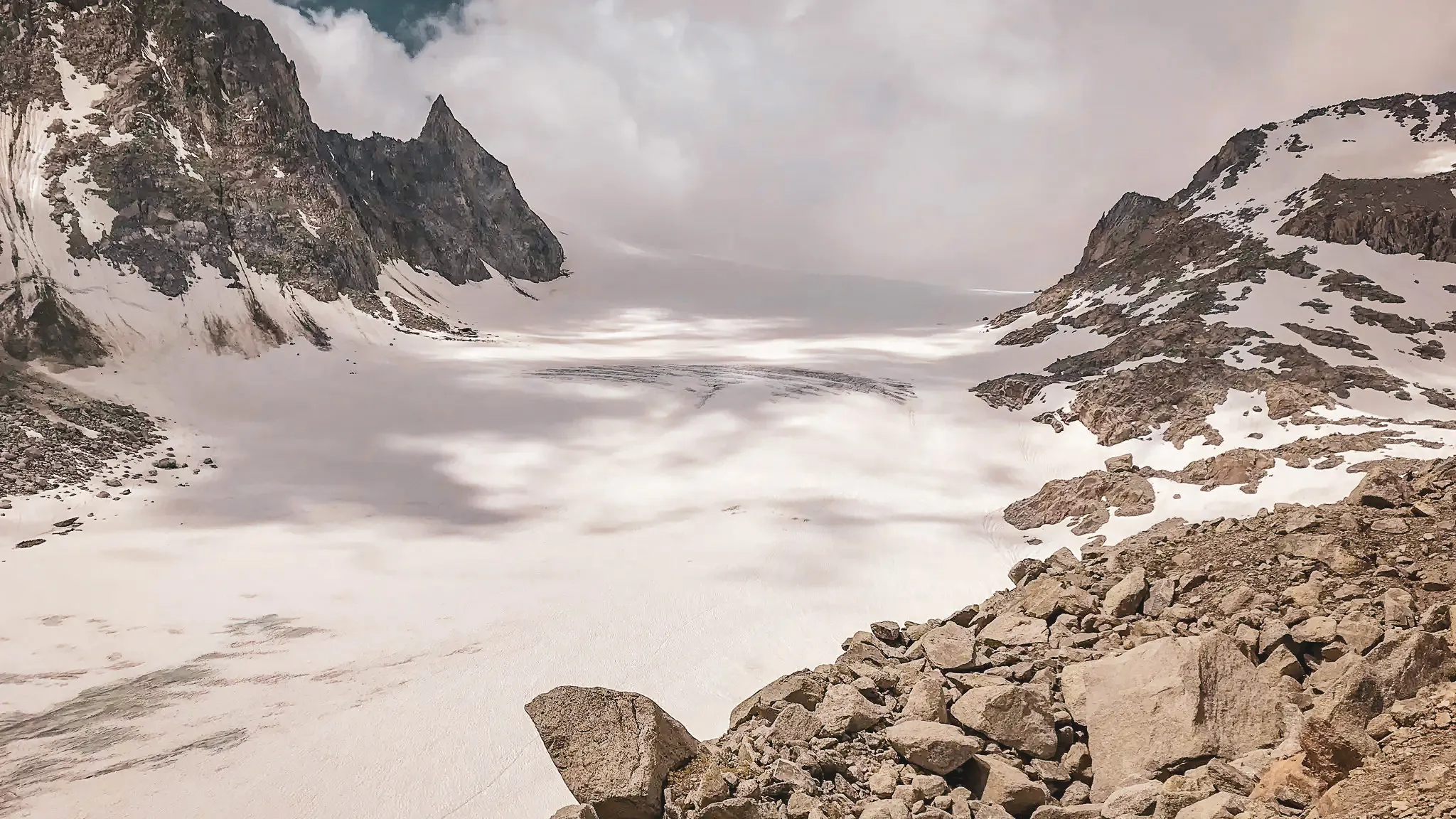 A panoramic view of a glacier, surrounded by majestic mountains, an invitation to alpine adventure.