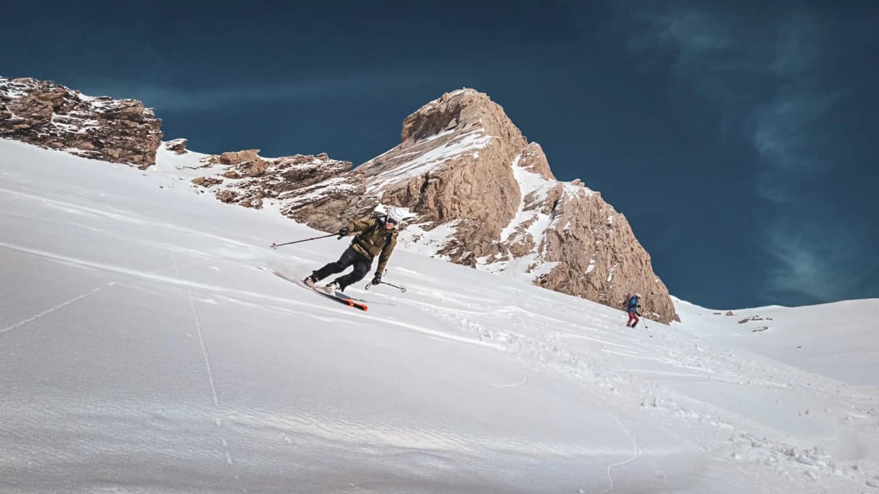 Ski de randonnée sur des pentes enneigées, avec le majestueux Mont Viso en arrière-plan.