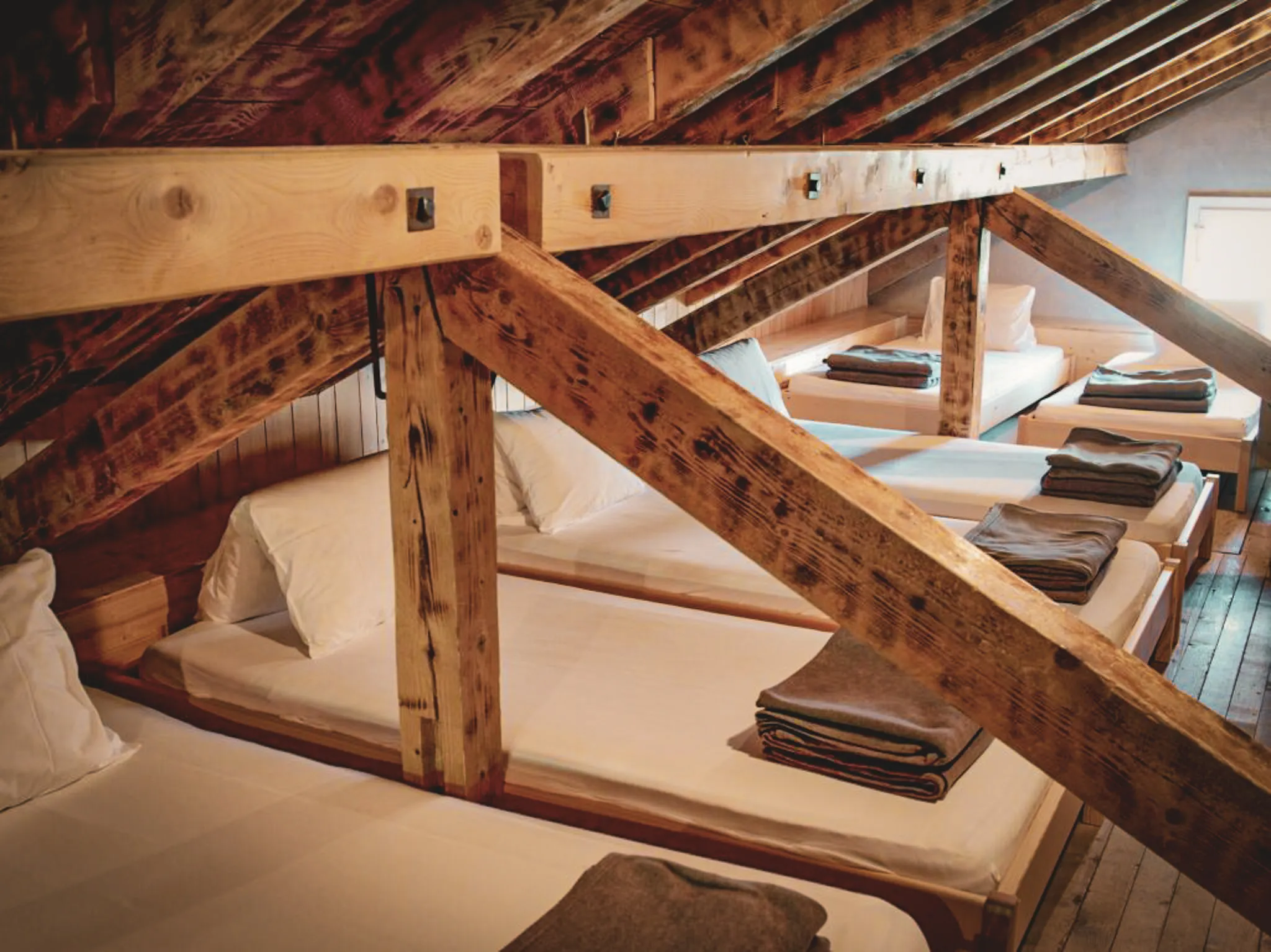 Wooden rooms with comfortable beds, ideal for relaxing after an alpine hike.