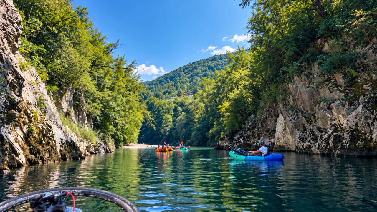 A group of packrafters glide peacefully across emerald waters surrounded by lush green cliffs.