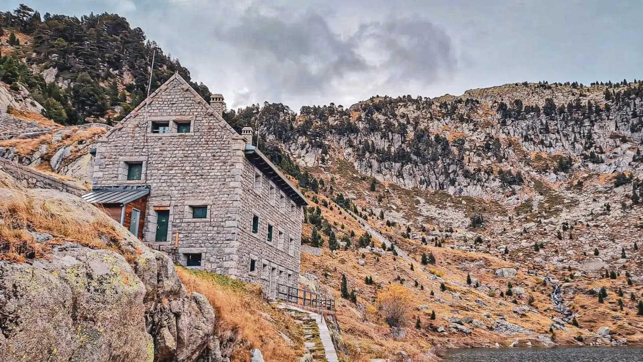 A stone Mountain hut in the heart of the mountains, surrounded by flower-filled valleys and majestic panoramas.