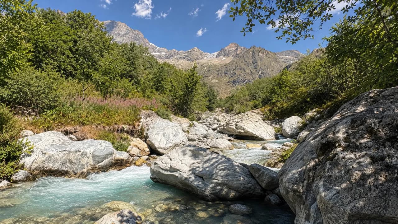 A beautiful valley with rocks, a turquoise river and mountains in the background.