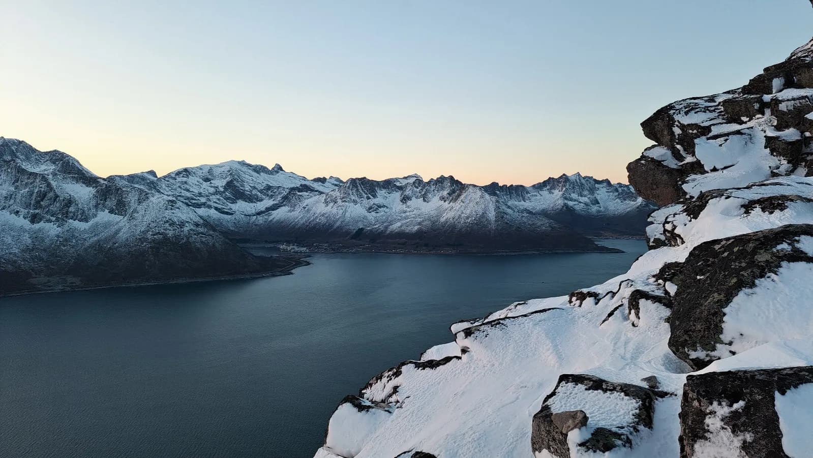 Spectaculair uitzicht op de Senja fjorden, Noorwegen, met majestueuze bergen en glinsterende sneeuw.
