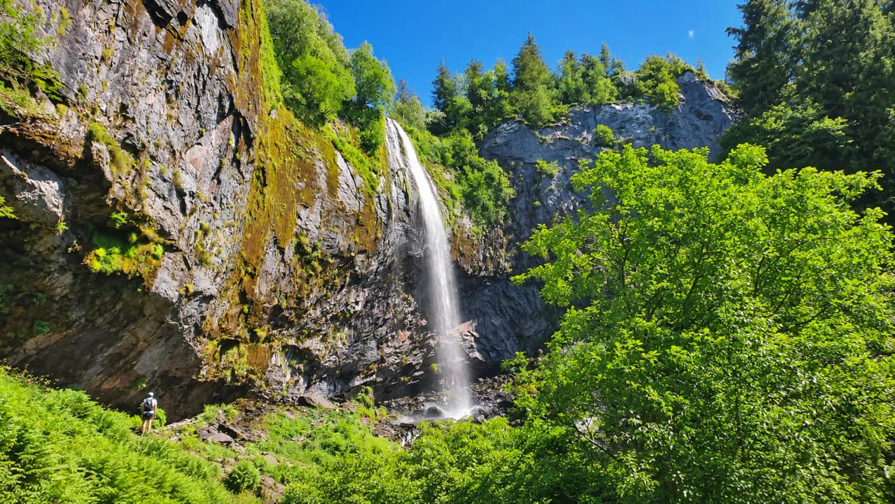Cascade majestueuse entourée de verdure luxuriante, idéale pour une aventure en pleine nature.