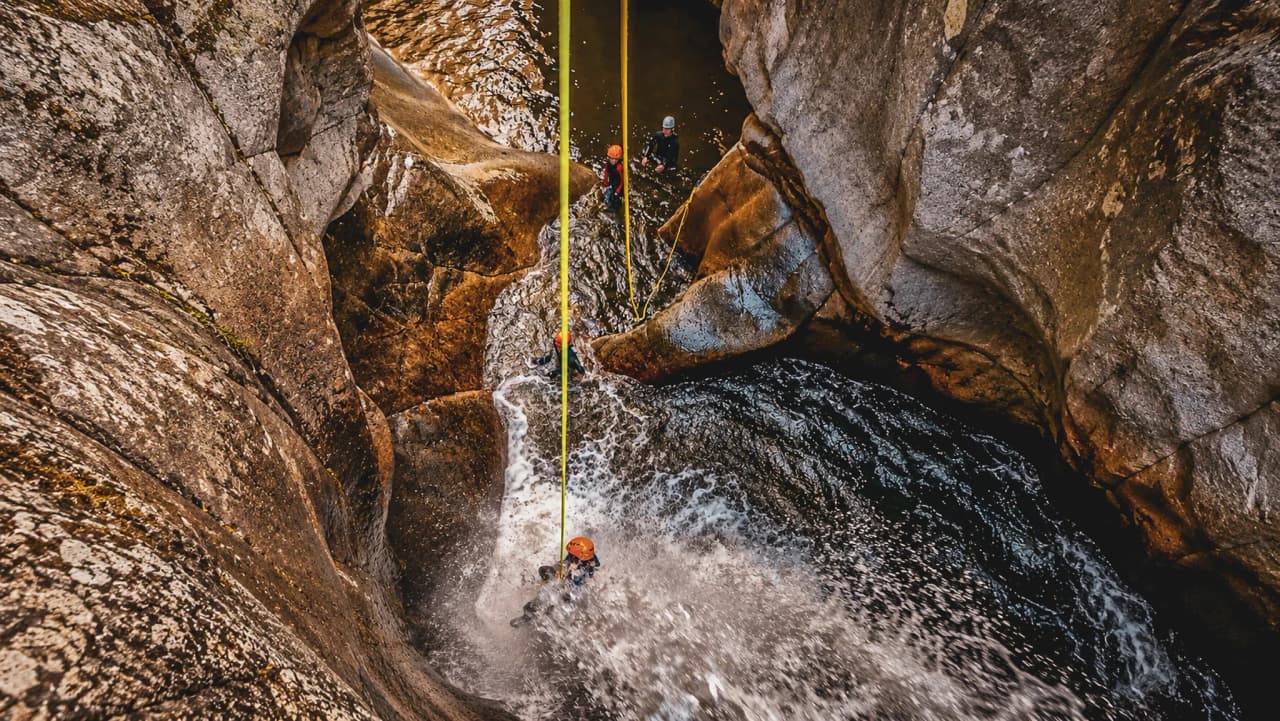 Canyon turquoise avec des aventuriers en pleine descente en rappel, entourés de rochers majestueux.