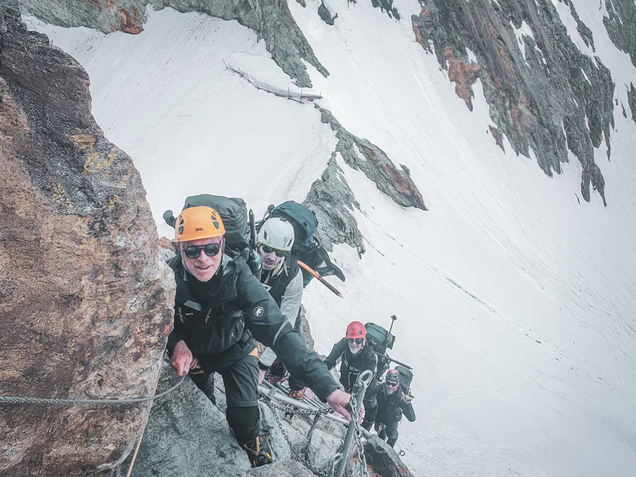 Mountain climbers on a glacier, surrounded by the majestic scenery of the Alps.