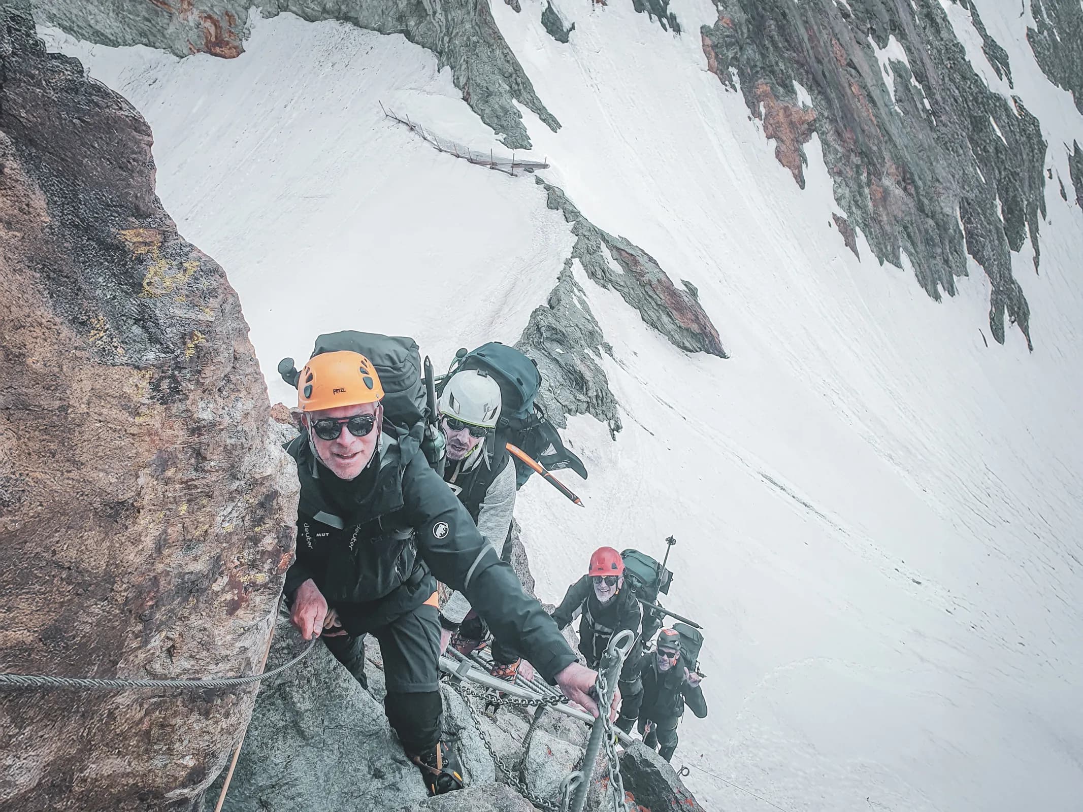 Mountain climbers on a glacier, surrounded by the majestic scenery of the Alps.