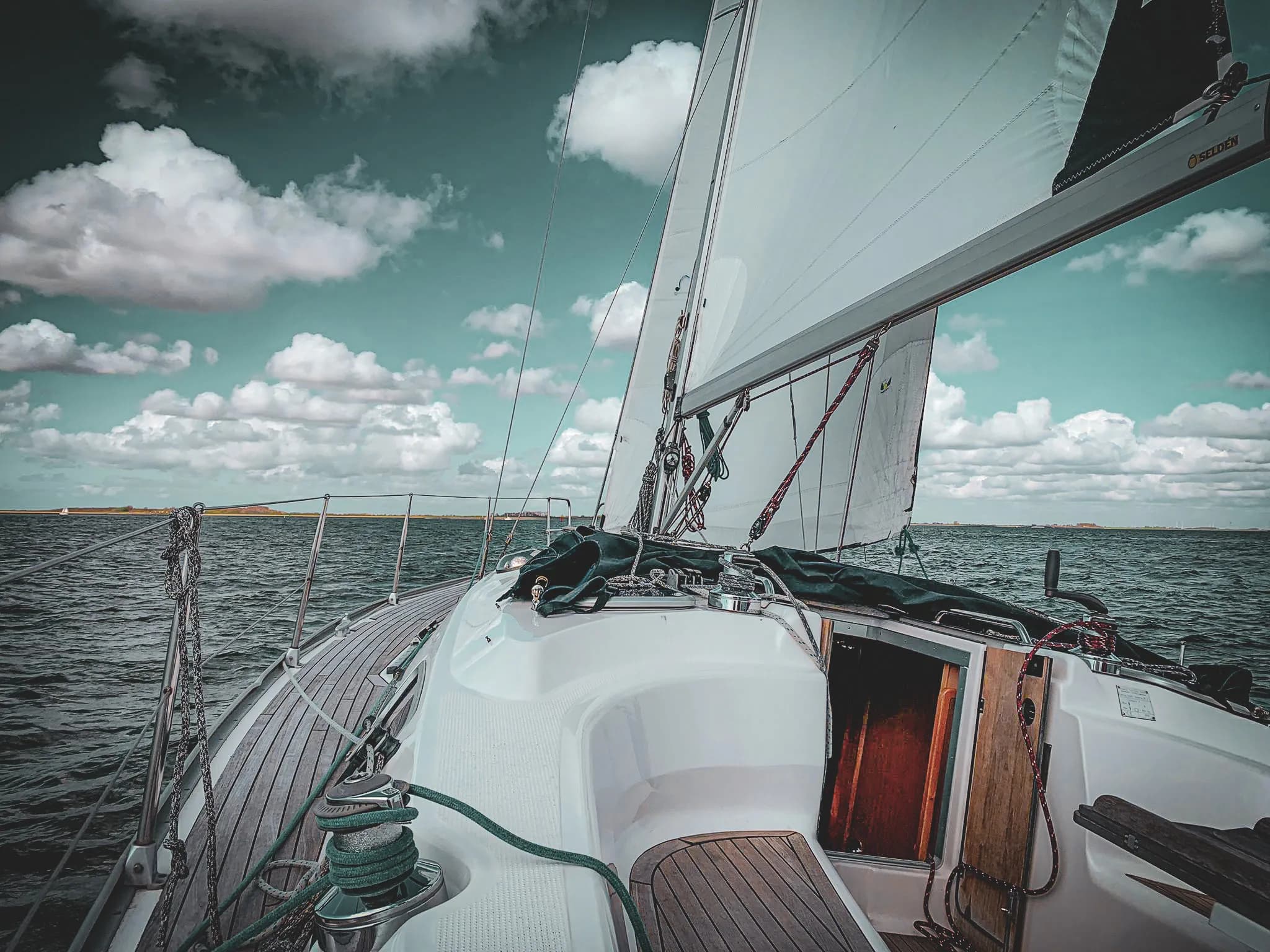 À bord d'un voilier, découverte des eaux paisibles de Zélande sous un ciel nuageux.
