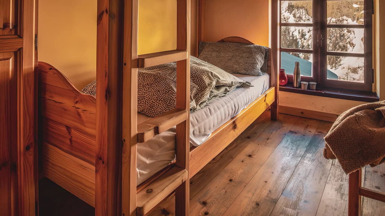 A cosy room with a wooden bed and a view of the peaceful Mont Blanc countryside.