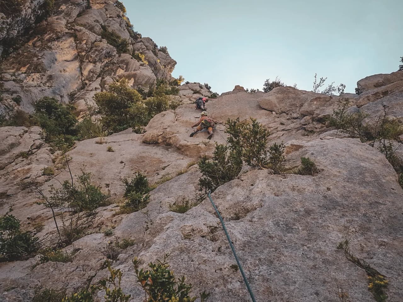 Climbing the cliffs of the Gorges du Verdon, surrounded by greenery and blue skies.
