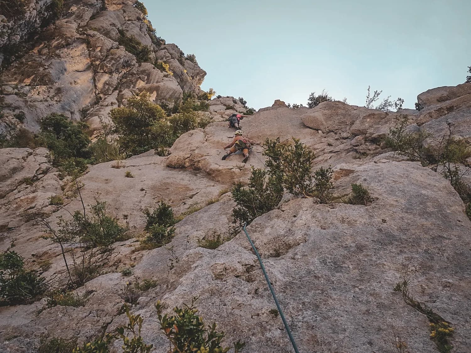 Climbing the cliffs of the Gorges du Verdon, surrounded by greenery and blue skies.