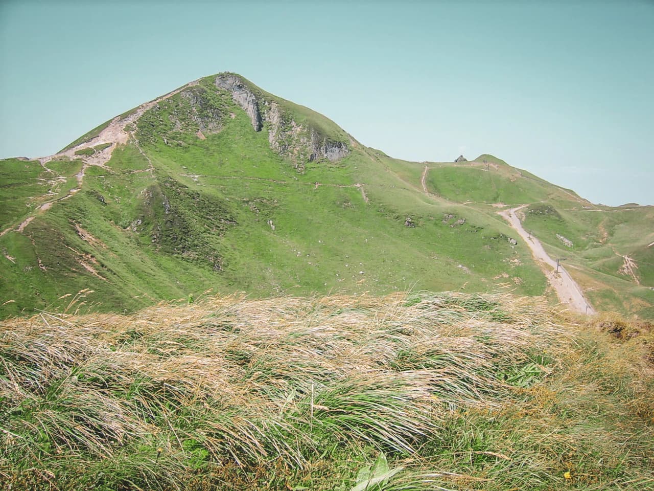 Panoramisch uitzicht vanaf een groene top, ideaal voor een wandeling in het Centraal Massief.