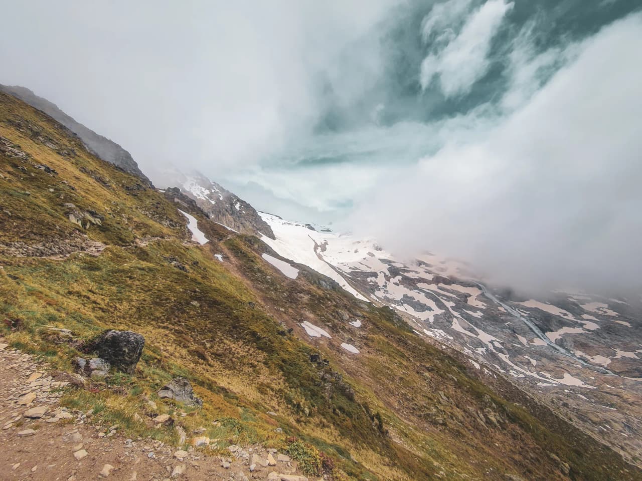 glacier landscapes, majestic mountains and soft clouds in the Alps.