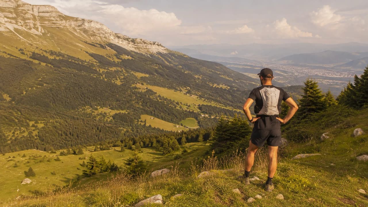 Un coureur contemplant les majestueuses montagnes verdoyantes de Chartreuse.