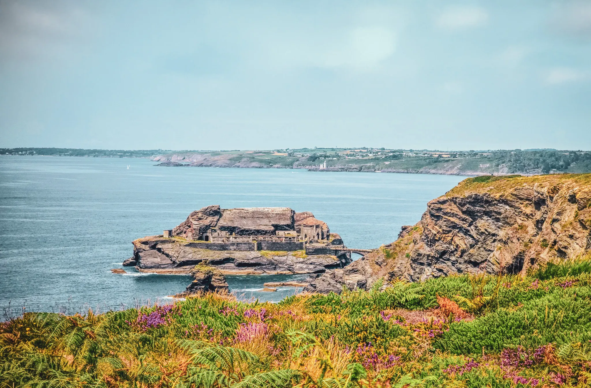 Falaises abruptes, eaux turquoises et végétation colorée, un panorama enchanteur de Bretagne.