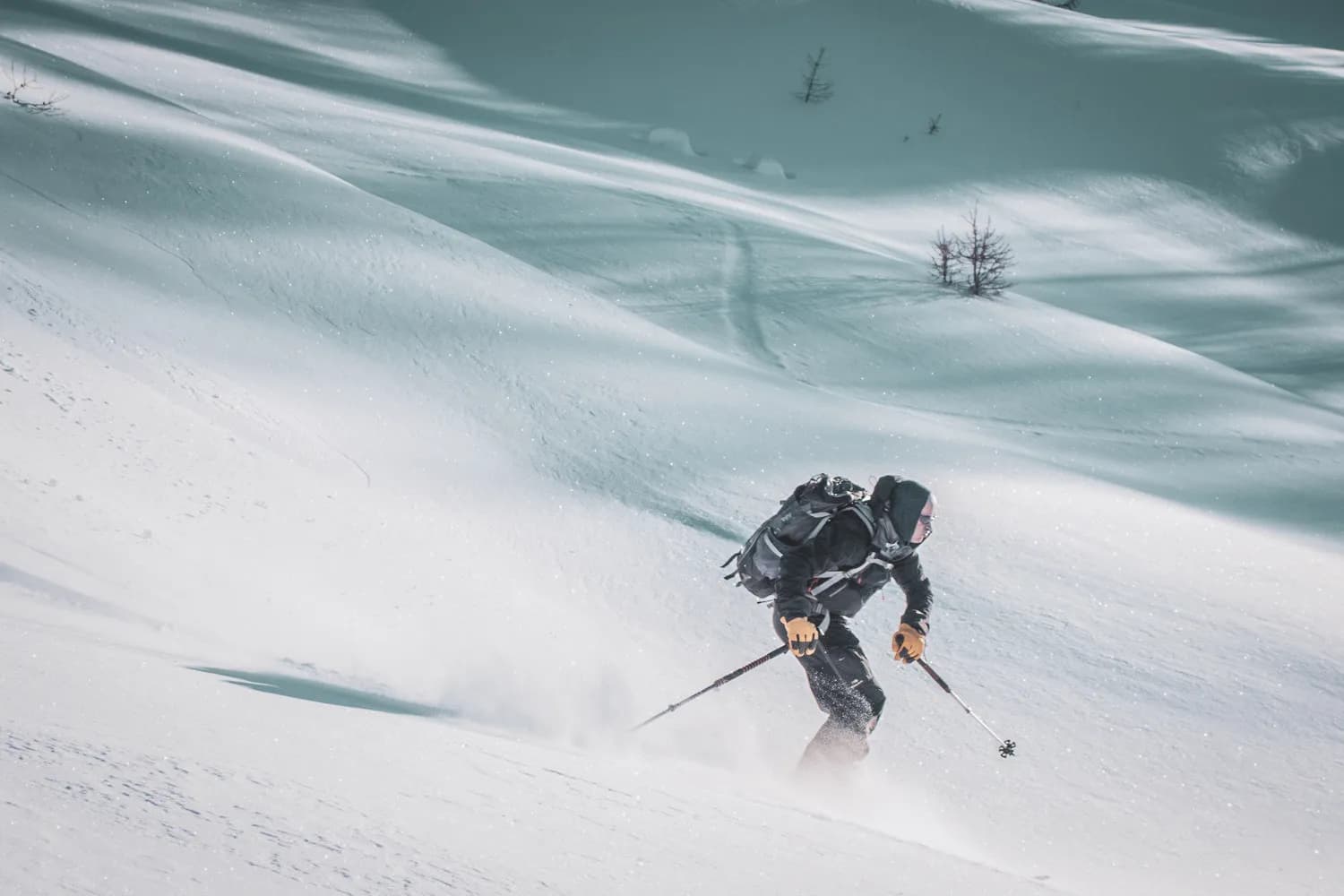 Skier descending a snow-covered slope in the Queyras, soft lighting and majestic scenery.