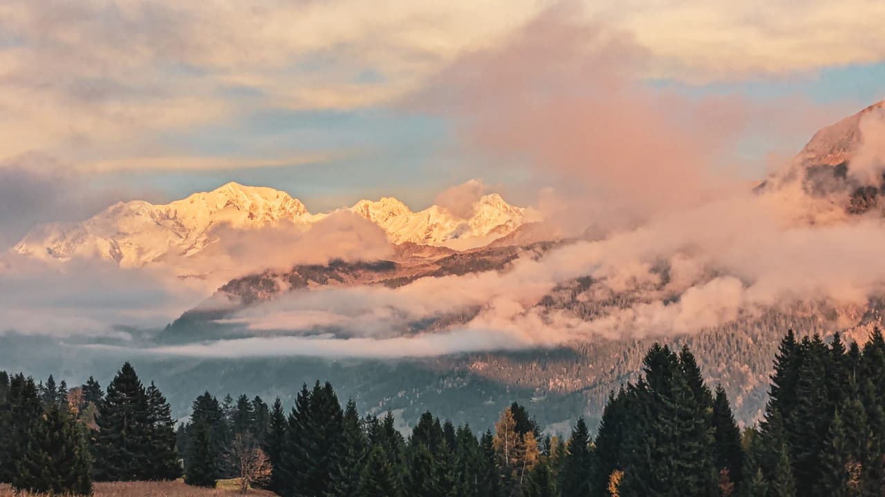 Montagnes majestueuses au crépuscule, enveloppées de brume, invitant à l'aventure.