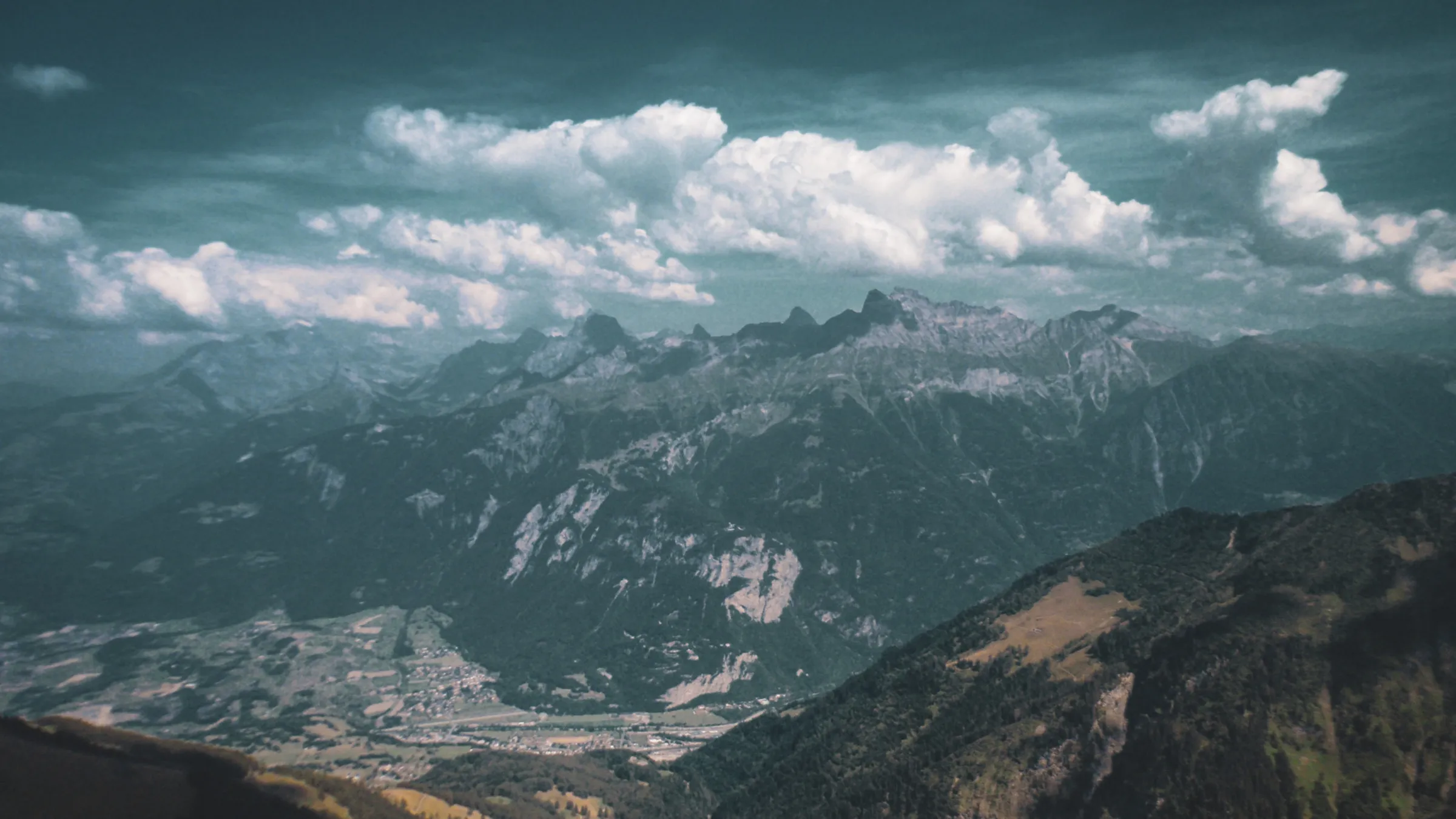 Paysage alpin spectaculaire avec montagnes escarpées et nuages, invitant à l'aventure.