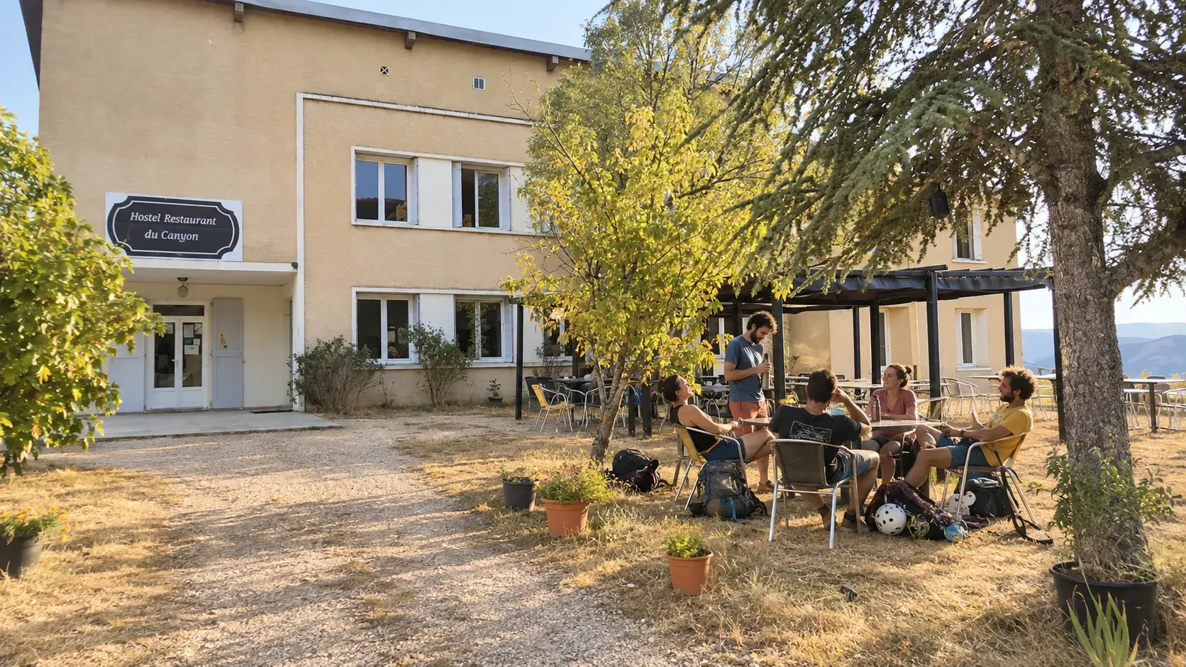 Groupe d'amis se détendant devant l'Auberge du Canyon, entourés de verdure et d'une ambiance conviviale.