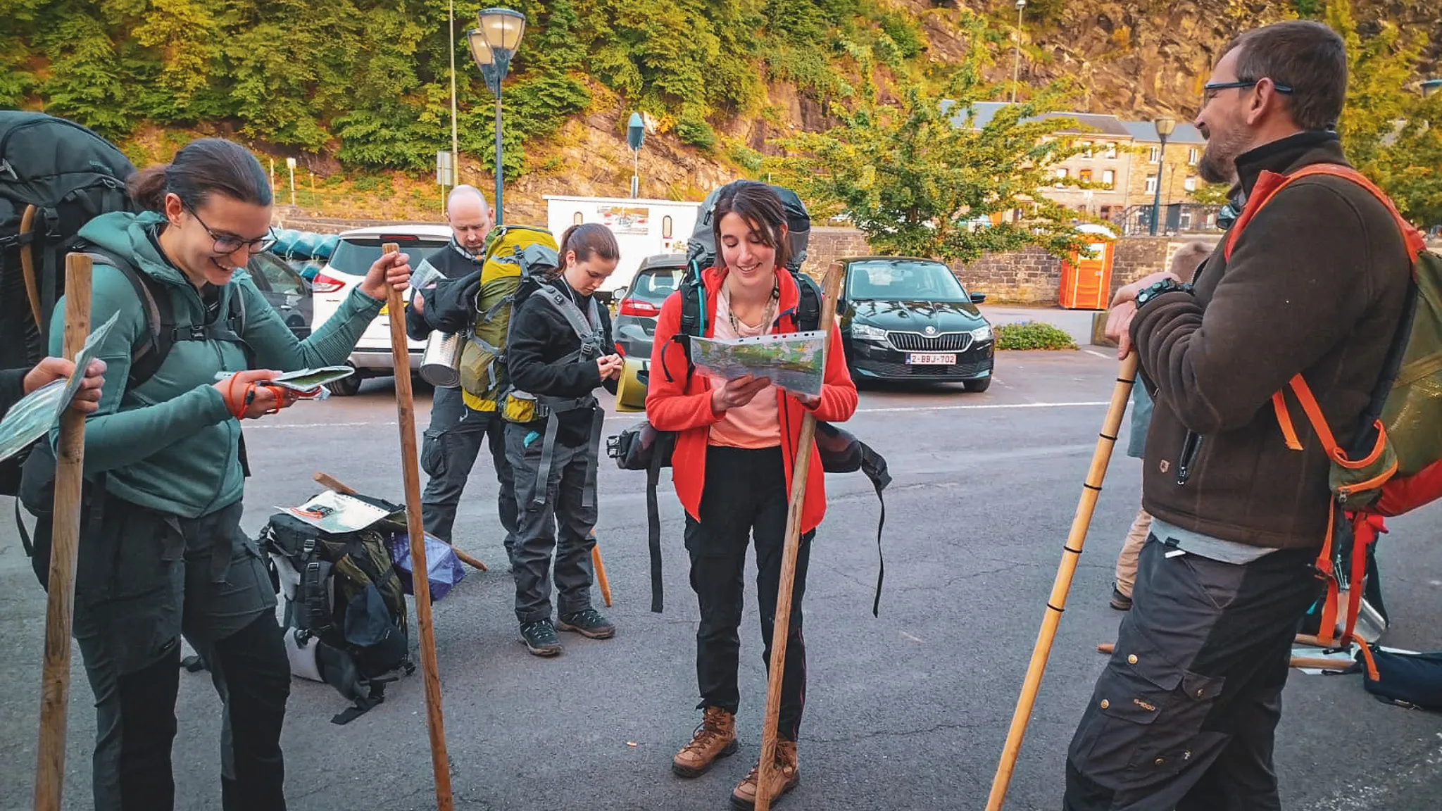 Groupe de participants souriants préparant leur expédition de survie en forêt en Ardenne.