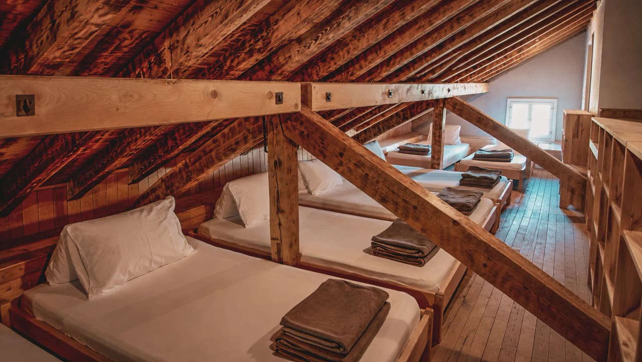 Refuge chaleureux sous les poutres en bois, lits confortables pour une nuit en pleine nature.