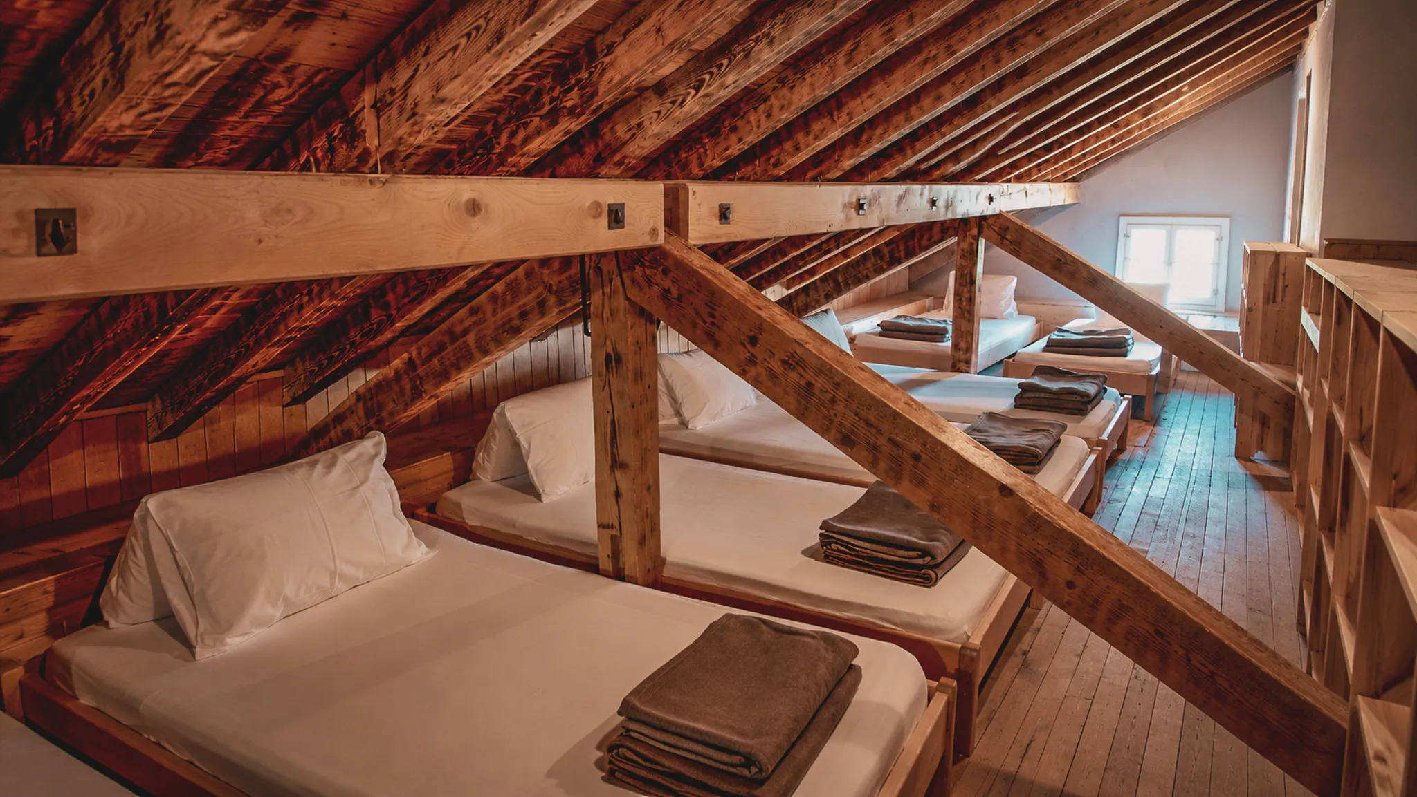 Refuge chaleureux sous les poutres en bois, lits confortables pour une nuit en pleine nature.