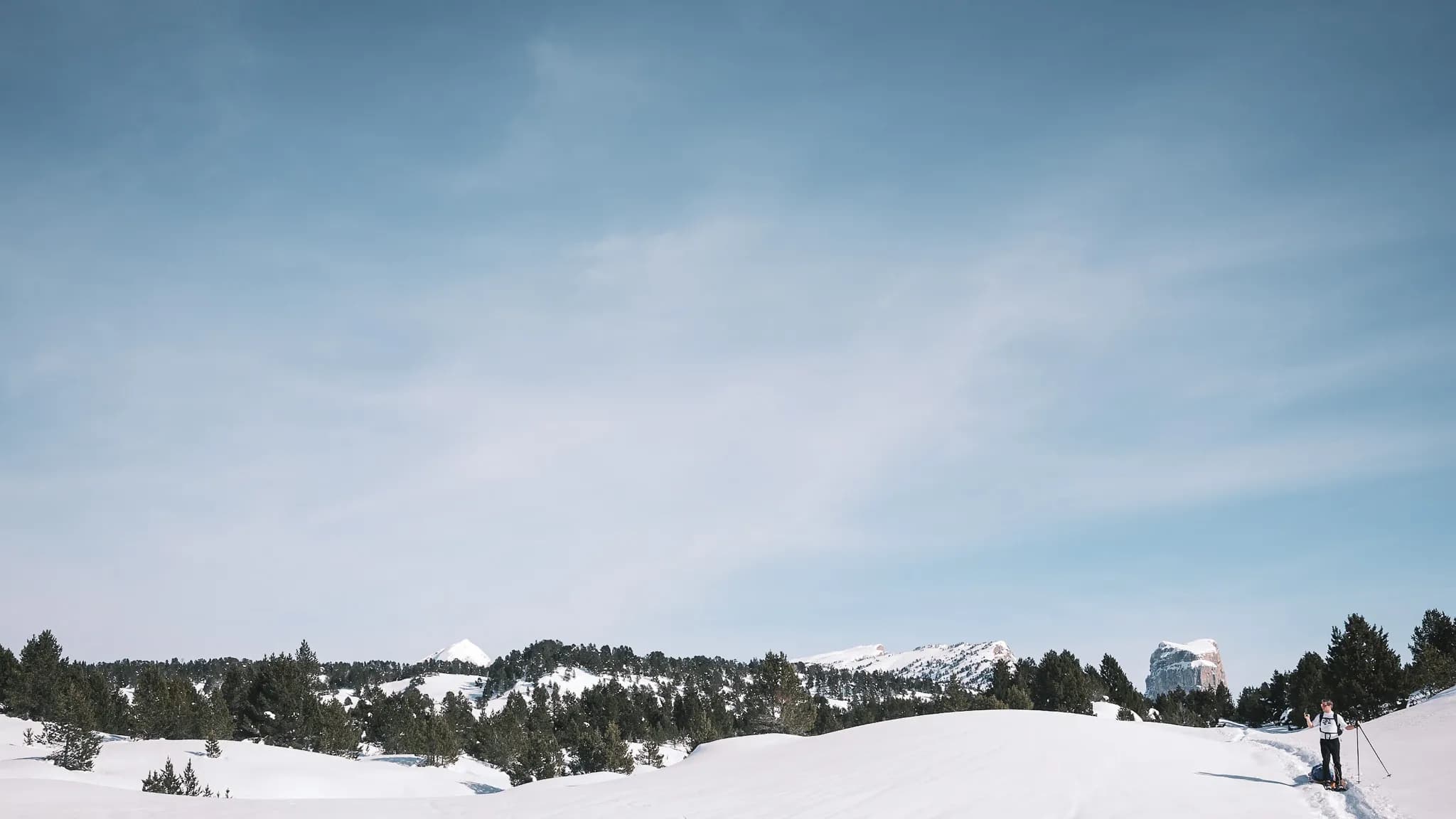 Un paysage enneigé du Vercors, avec raquettes sur le sentier et montagnes majestueuses.