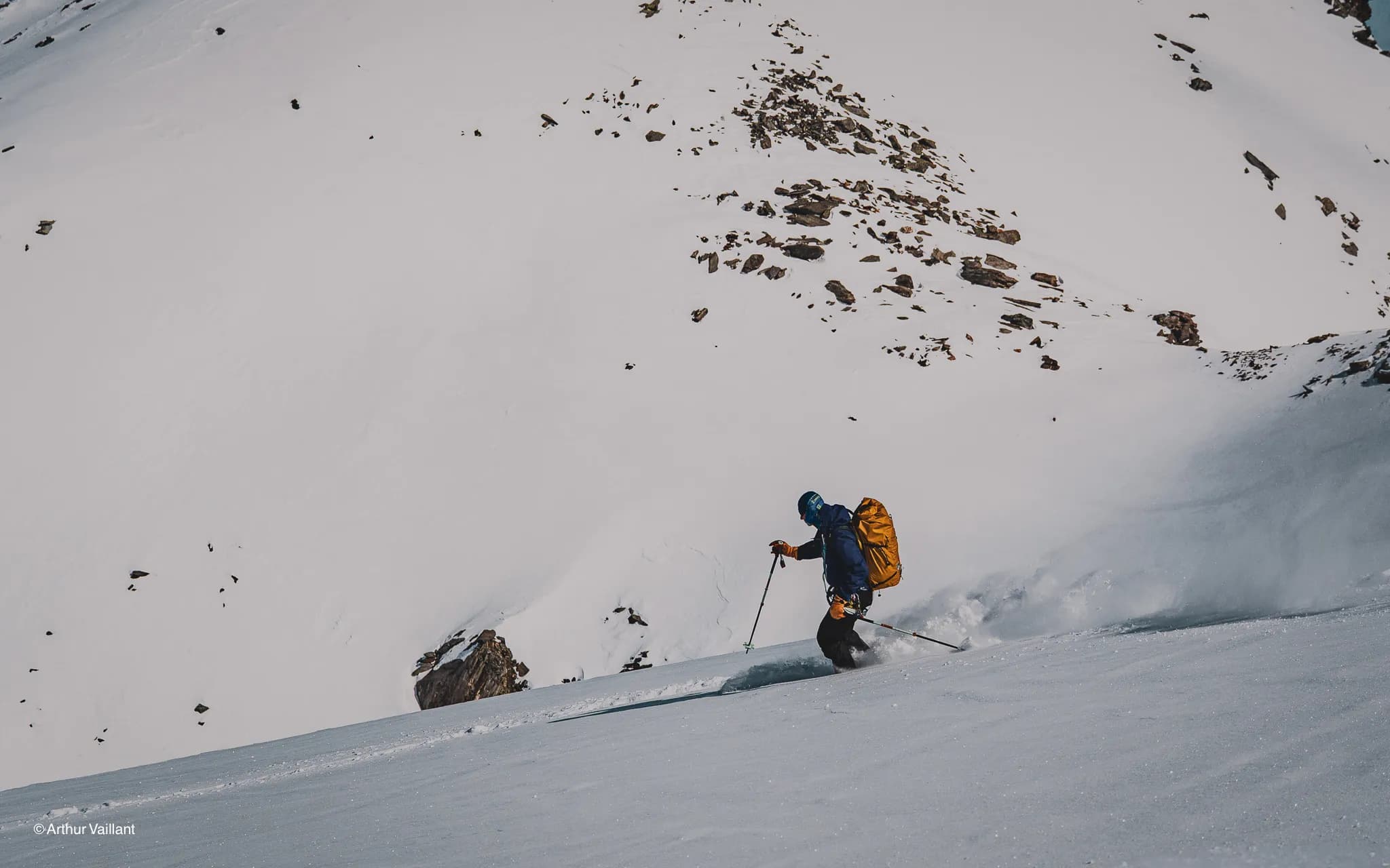 A skier hurtling down snow-covered slopes, surrounded by majestic glaciers.