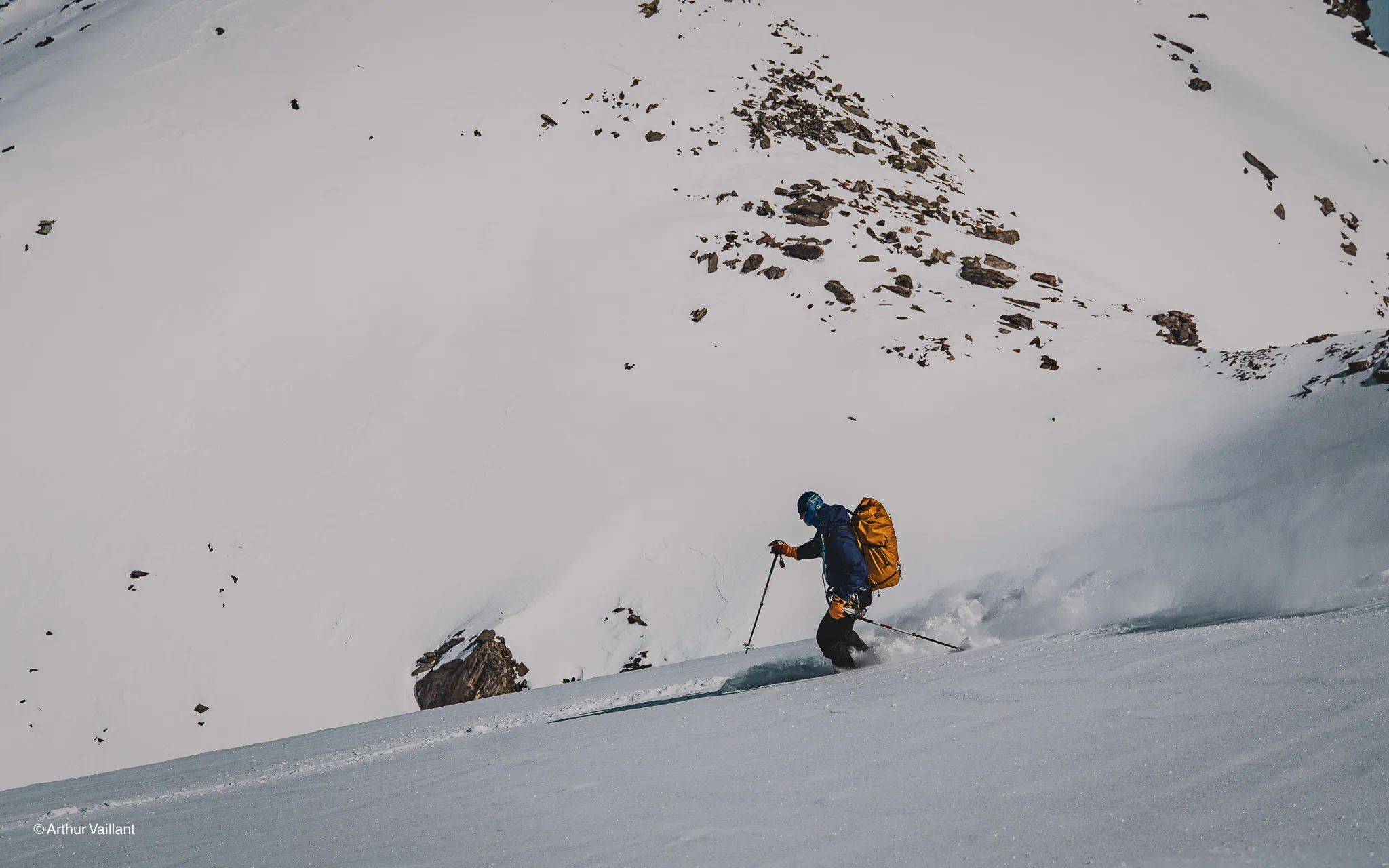 A skier hurtling down snow-covered slopes, surrounded by majestic glaciers.